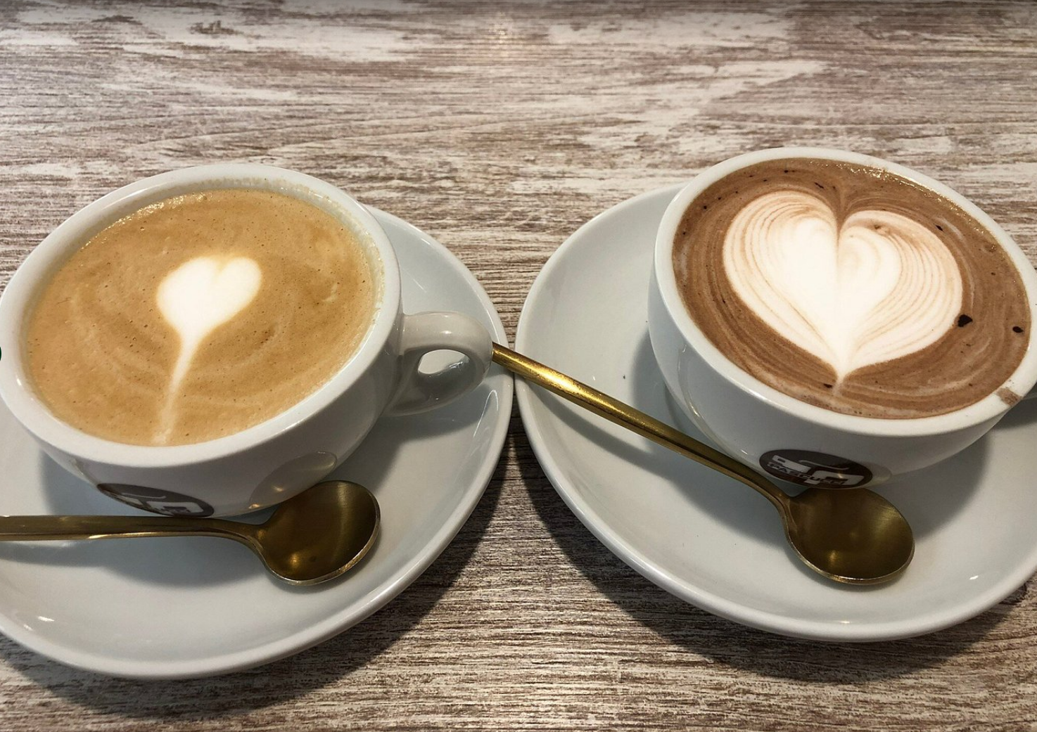 Two cappuccinos with latte art